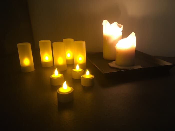 Teelichter mit Batterie zum aufladen neben echten Kerzen zur Deko