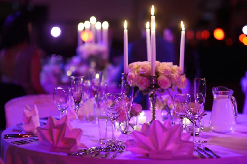 Elegant gedeckter Tisch für die Hochzeitsfeier mit silbernen 5-armigen Spitzkerzenständern