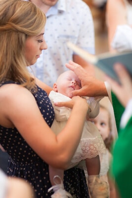 Kirchliche Taufe des Säuglings - in den Armen der Mutter