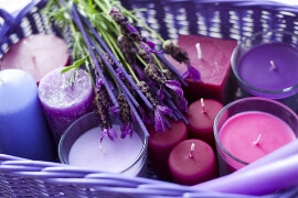 Korb voller Zylinder-Candles in lilafarbtönen (brombeere, flieder, taube, violett, blue, rosa)