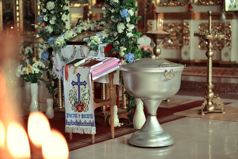 Taufaltar und Becken mit Blumen geschmückt und Kreuz-Symbol