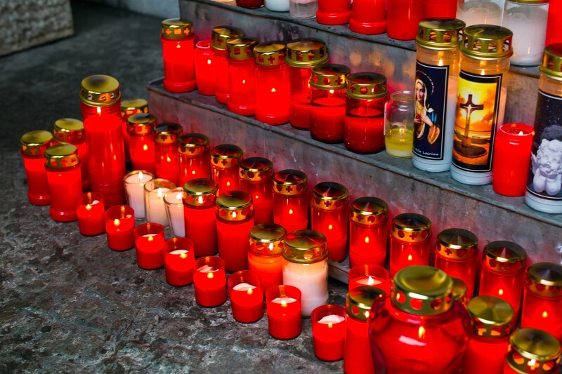 Viele weiße und rote Lichter aufgestellt an einem Grab-Denkmal